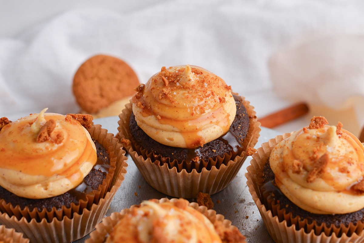 close up angled shot of pumpkin cream cheese frosting on chocolate cupcakes