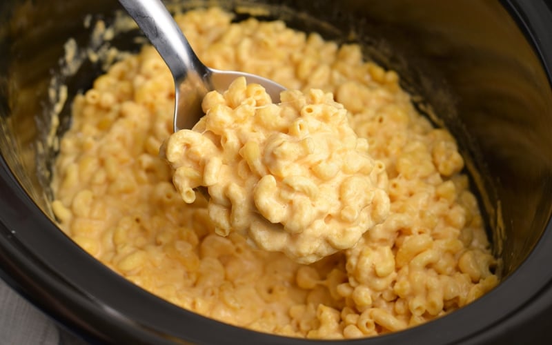 angled shot of serving spoon full of creamy mac and cheese