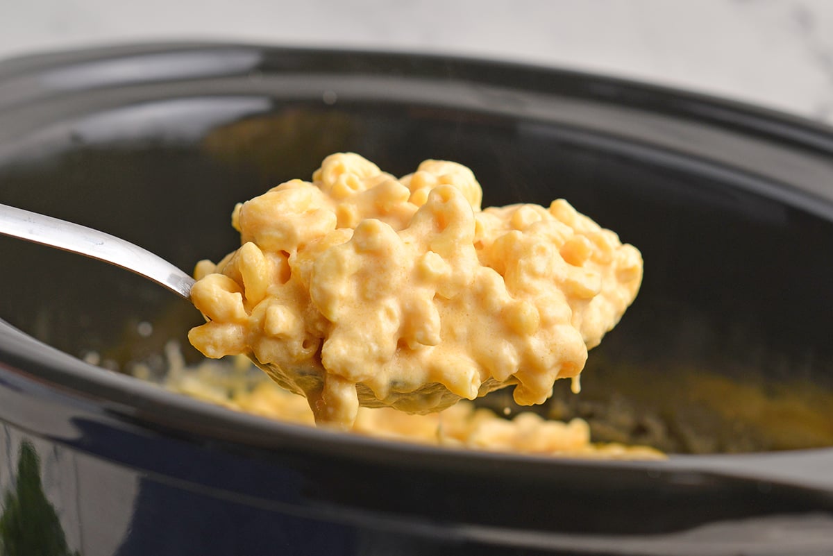 straight on shot of ladle full of crock pot mac and cheese