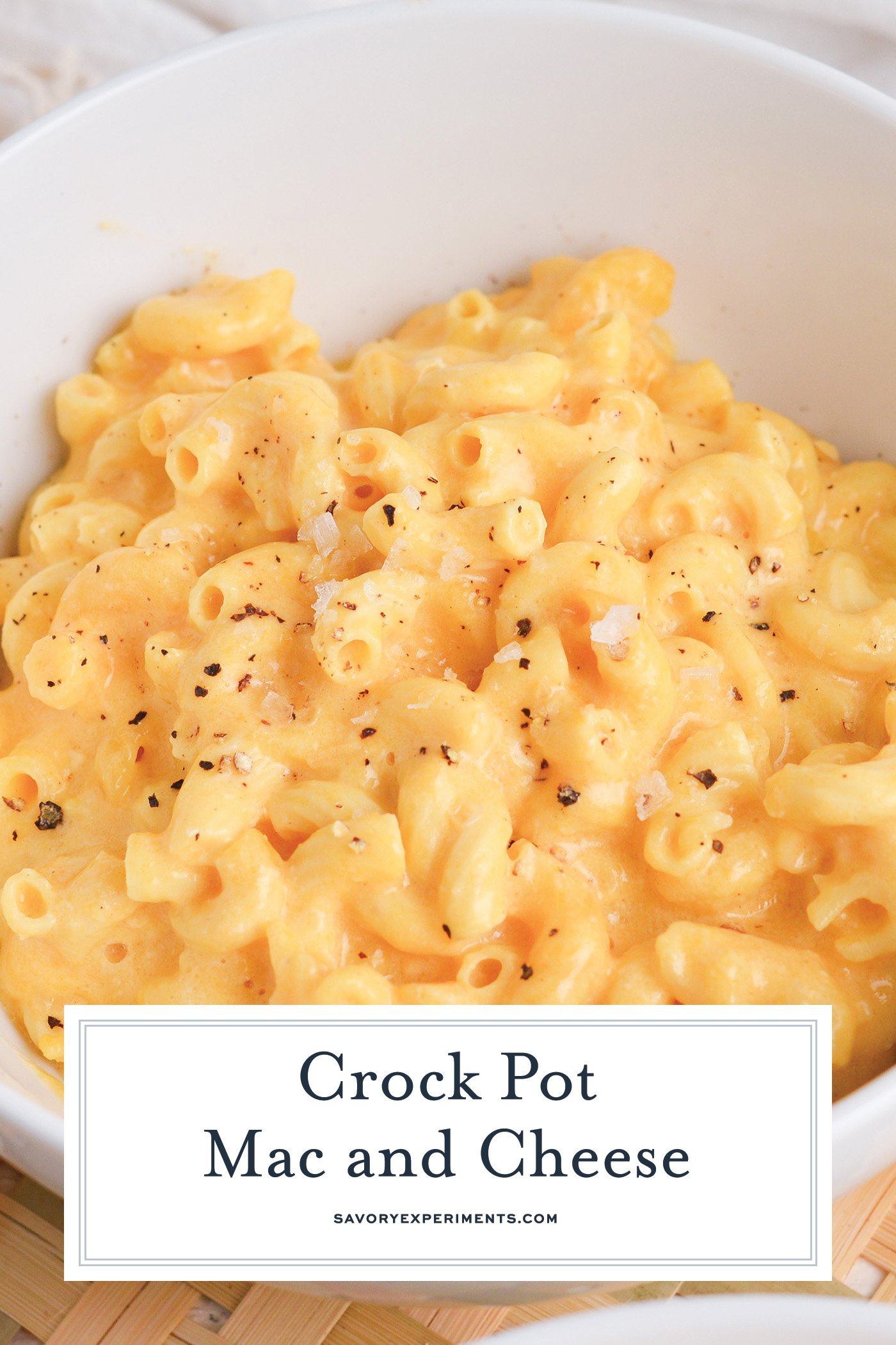 close up angled shot of bow of crock pot mac and cheese with text overlay for pinterest