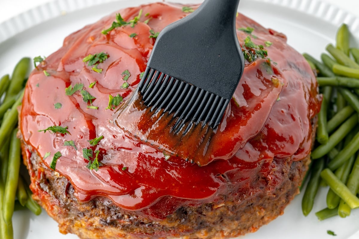 brushing sauce on meatloaf