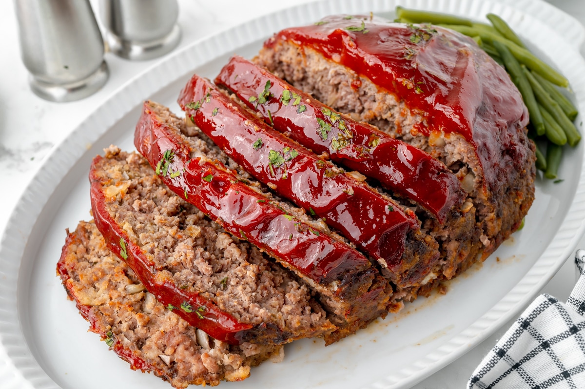 angled shot of sliced slow cooker meatloaf on a platter