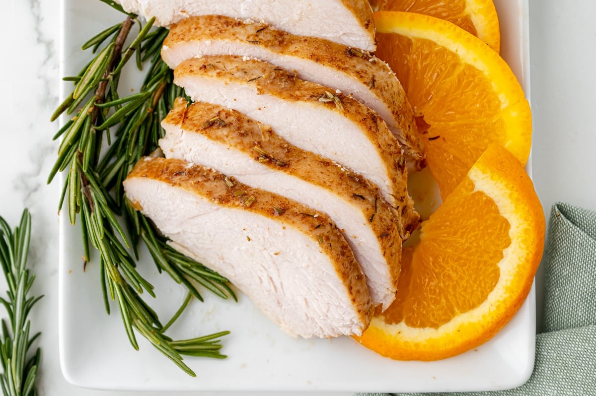 overhead shot of sliced turkey breast on platter with oranges