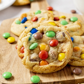 angled shot of soft m&m cookies on board