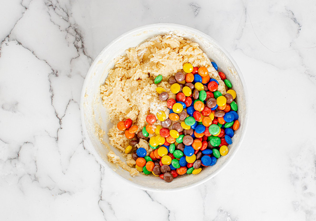overhead shot of m&ms in bowl of cookie dough