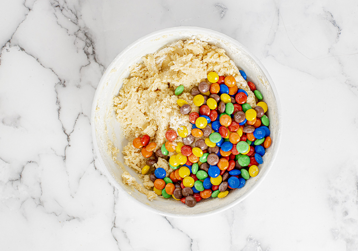 overhead shot of m&ms in bowl of cookie dough