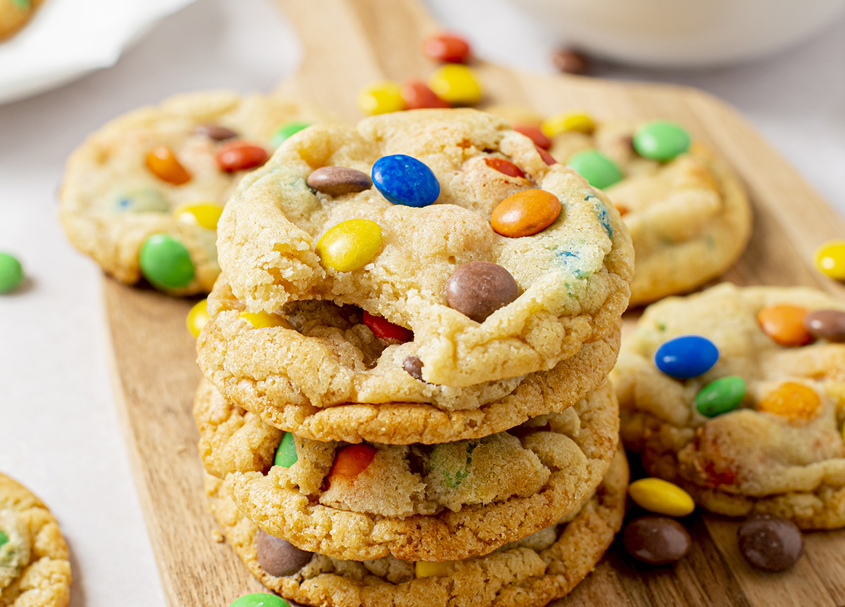 angled shot of bite taken out of stack of soft m&m cookies