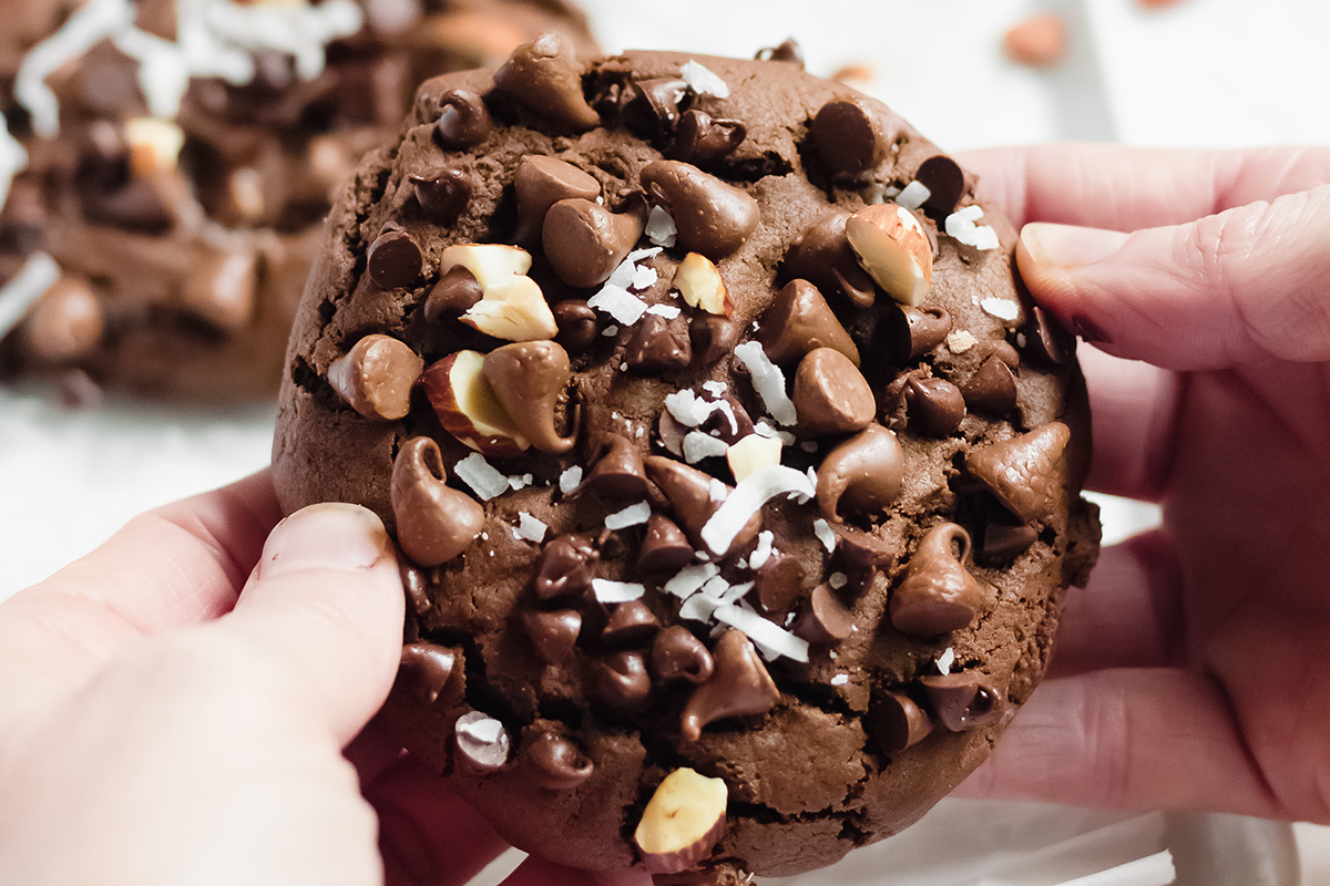 hand breaking apart a almond joy cookie