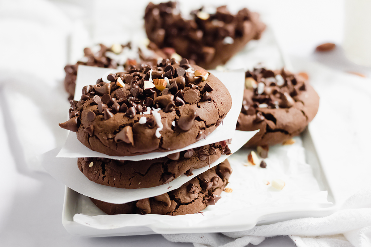 stack of almond joy cookies separated by parchment paper