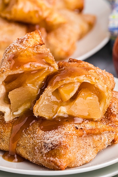 close up straight on shot of apple pie egg roll cut in half on plate