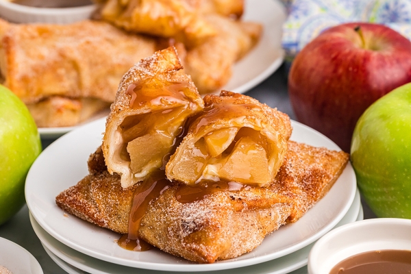 close up straight on shot of apple pie egg roll cut in half on plate