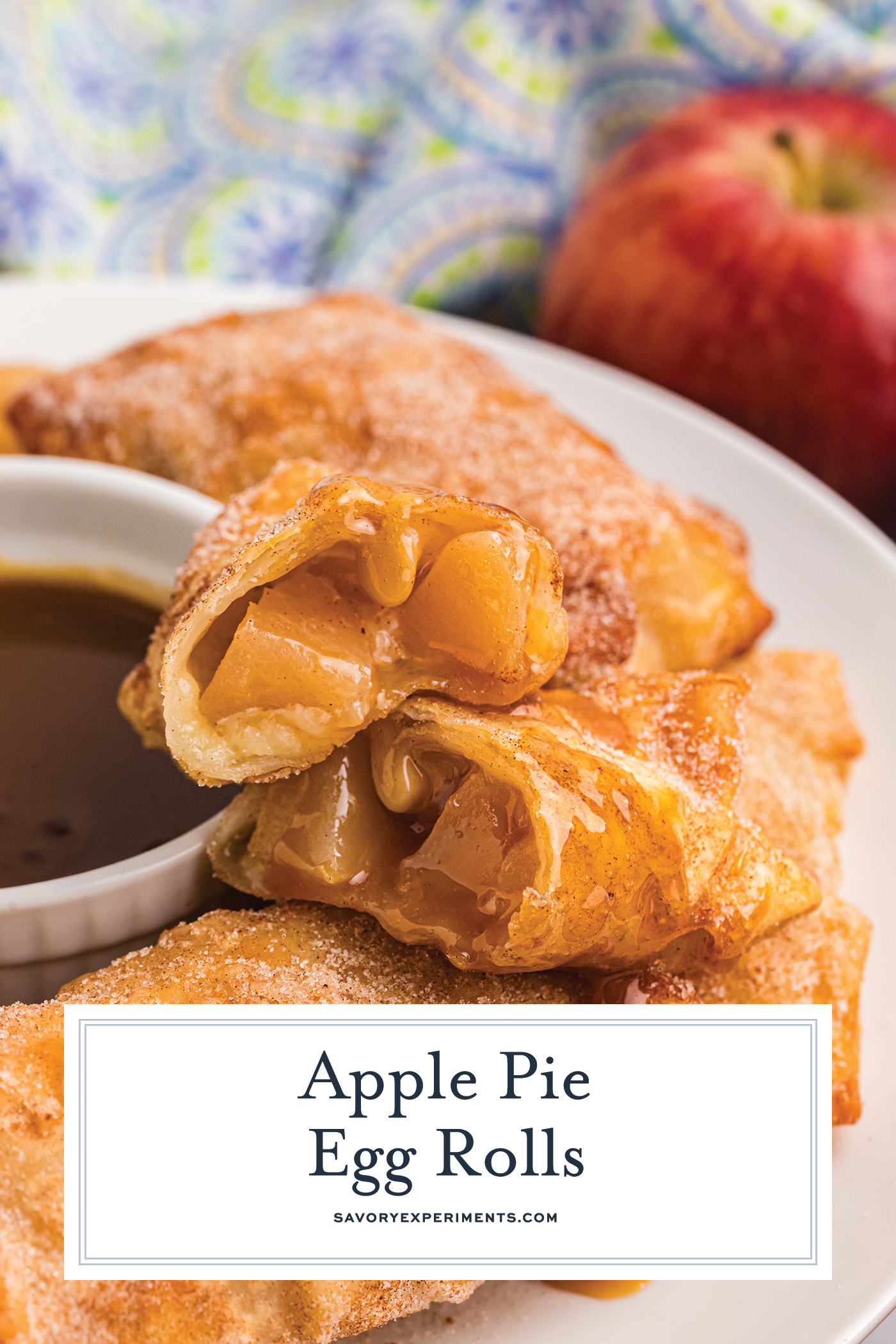 angled shot of apple pie egg roll cut in half with text overlay for pinterest