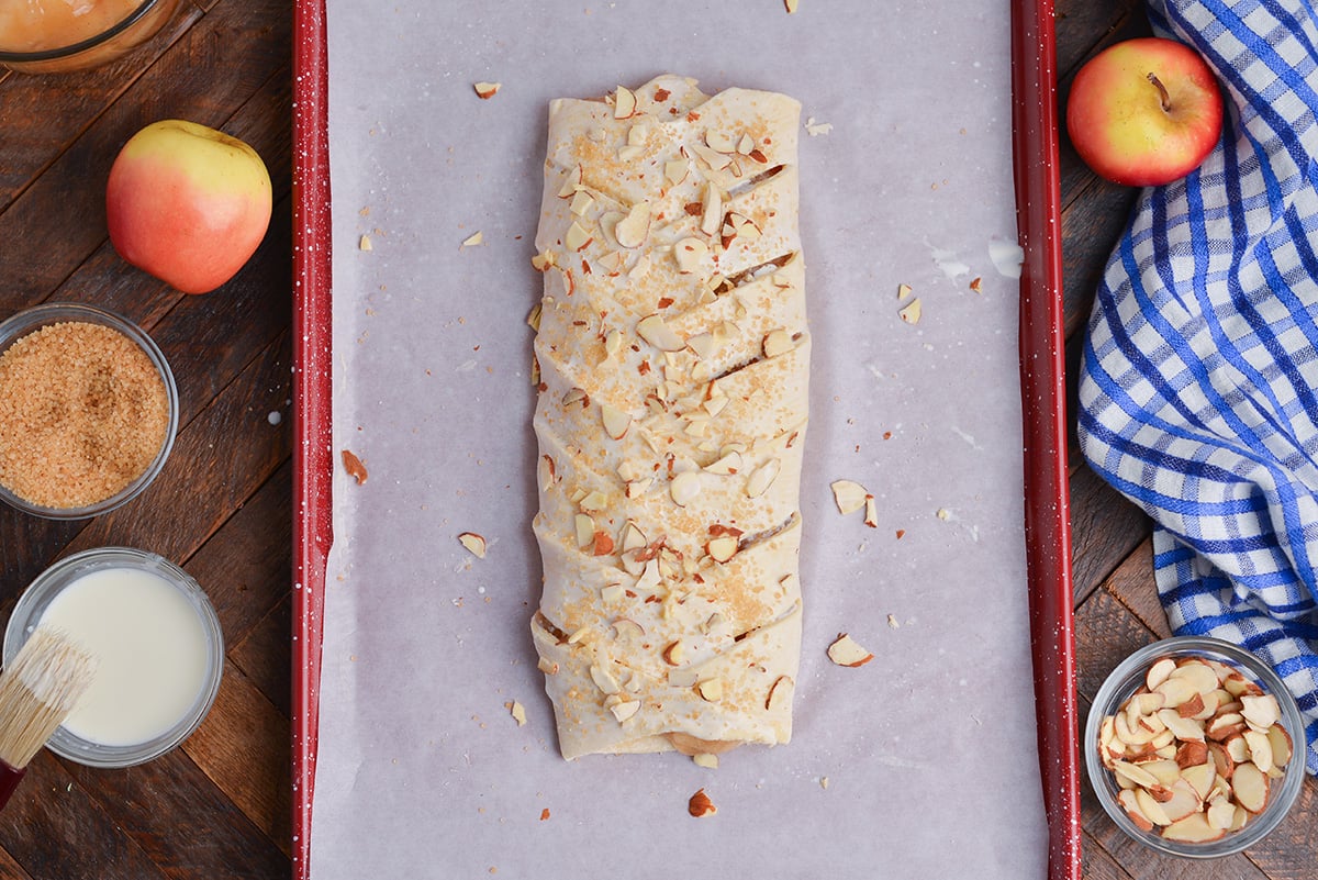 overhead shot of sugar and almonds sprinkled on apple strudel