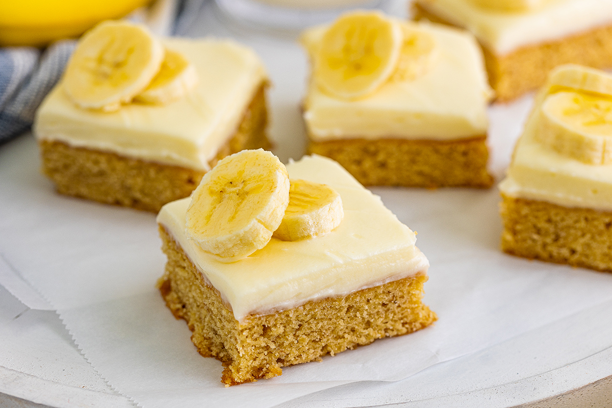 close up of a blondie with frosting and banana slices