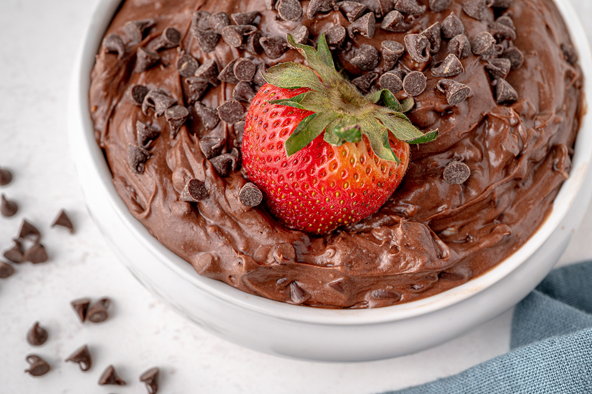 strawberry dipped into a bowl of brownie mix dip