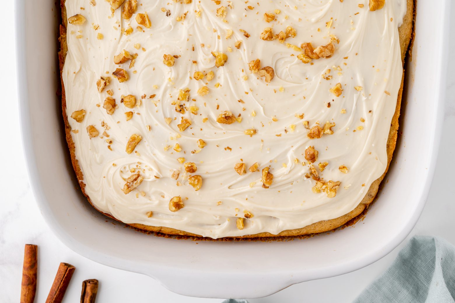close up overhead of butternut squash sheet cake with cream cheese frosting and walnuts