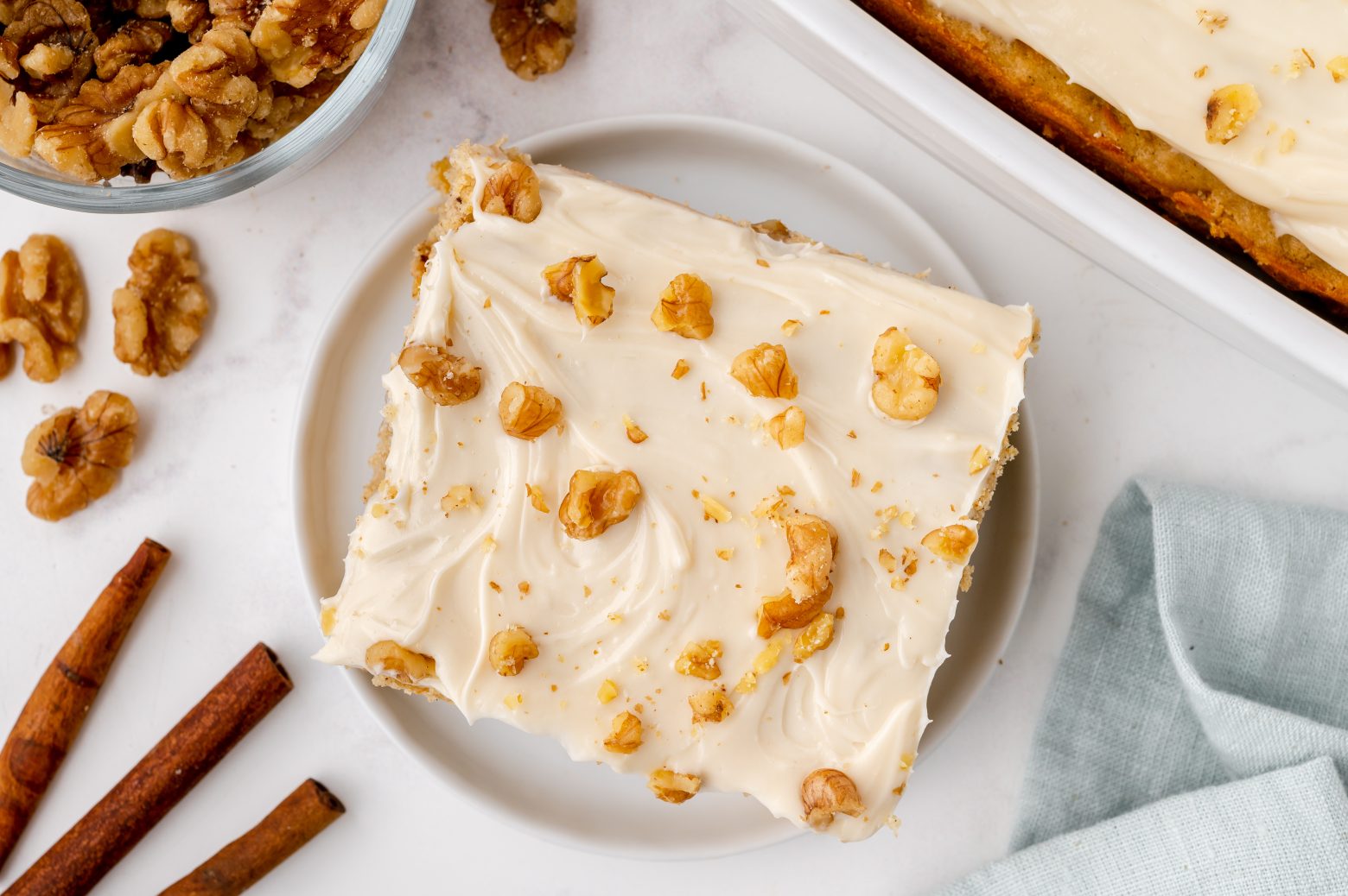 close up overhead slice of cake with cinnamon sticks and walnuts