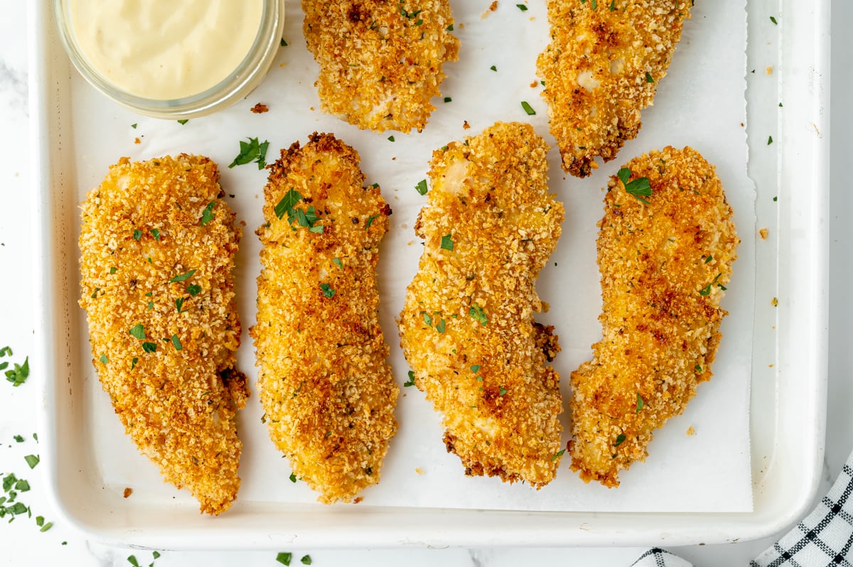 close up overhead shot of crispy baked chicken tenders on sheet pan