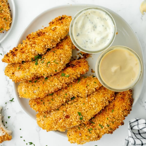 overhead shot of plate of crispy baked chicken tenders with dipping sauces