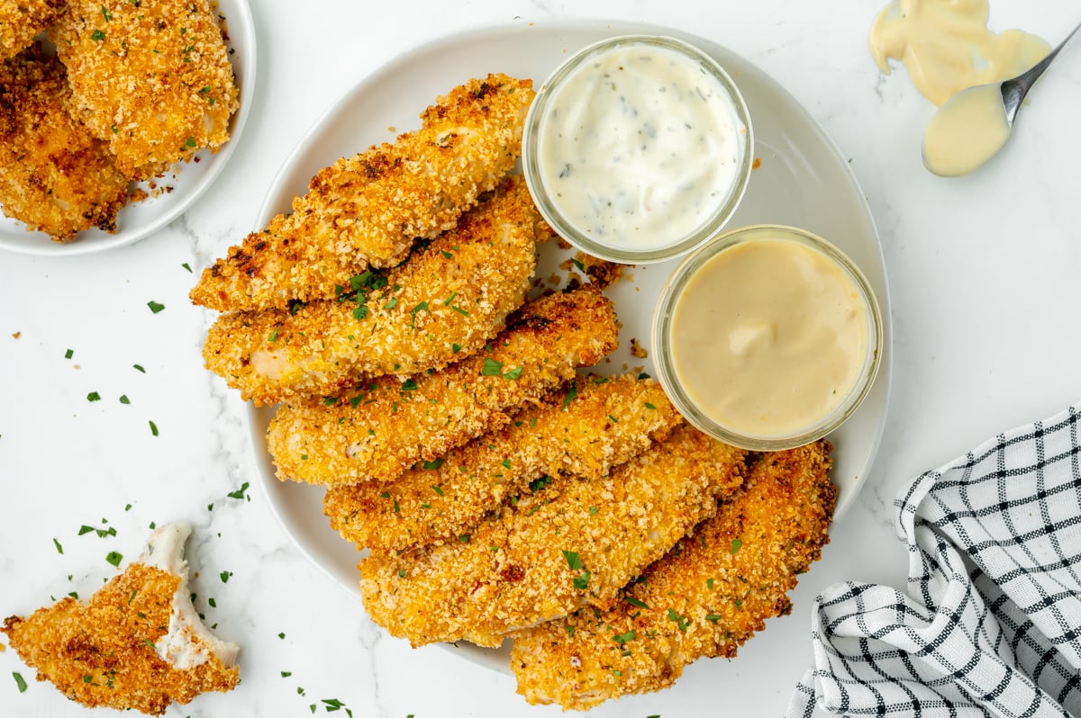 overhead shot of plate of crispy baked chicken tenders with dipping sauces