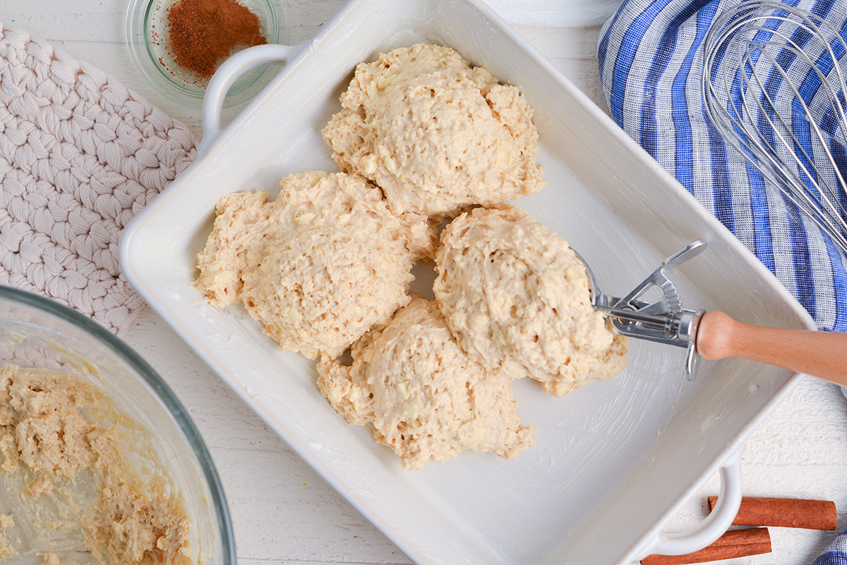 overhead shot of biscuit dough scooped into baking dish