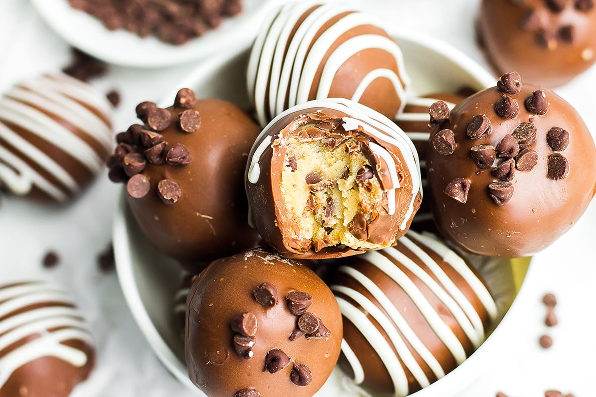 bowl of cookie dough truffles with a bite taken out