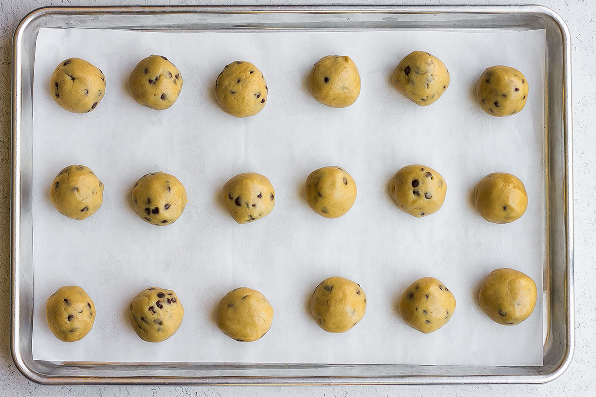 cookie dough balls on a parchment lined baking sheet
