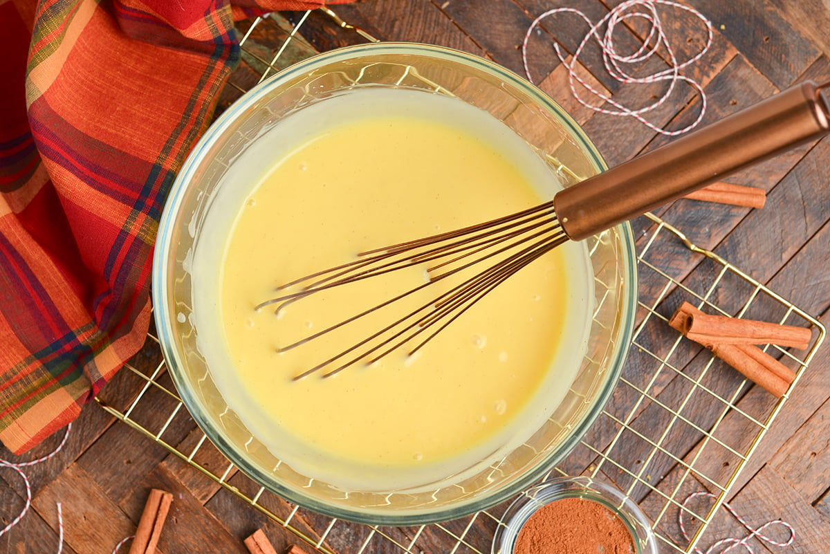 overhead shot of eggnog pudding in bowl with whisk