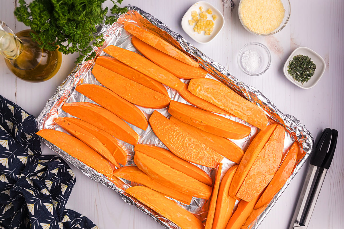 sweet potato wedges on sheet pan lined with aluminum foil