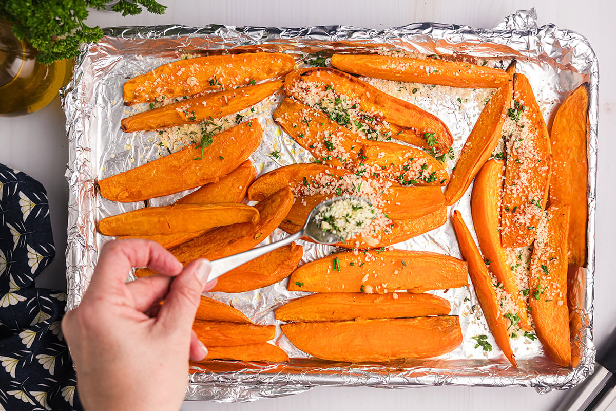 spoon adding seasoning to sweet potatoes