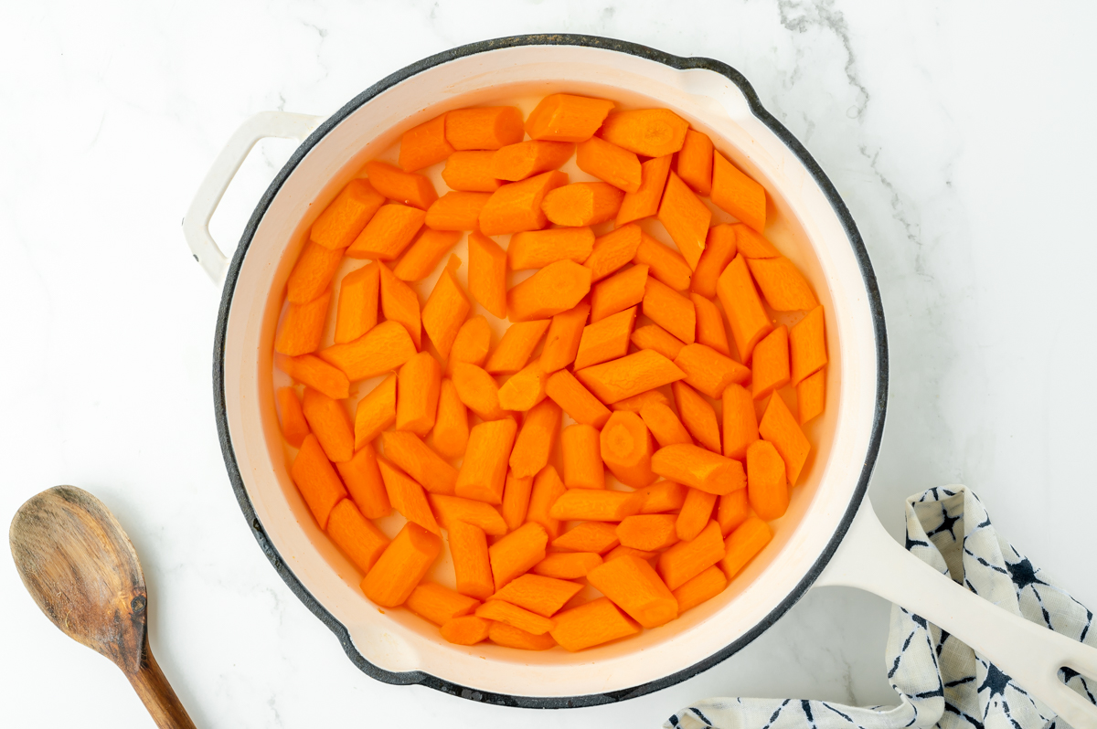 overhead shot of carrots cooking in pan with water