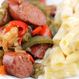 close up angled shot of kielbasa and peppers with alfredo sauce