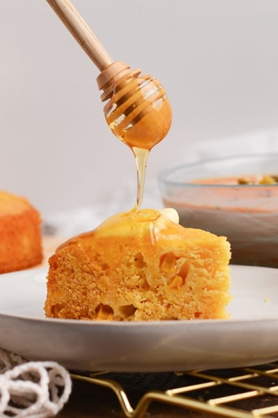 straight on shot of honey dripping onto cornbread