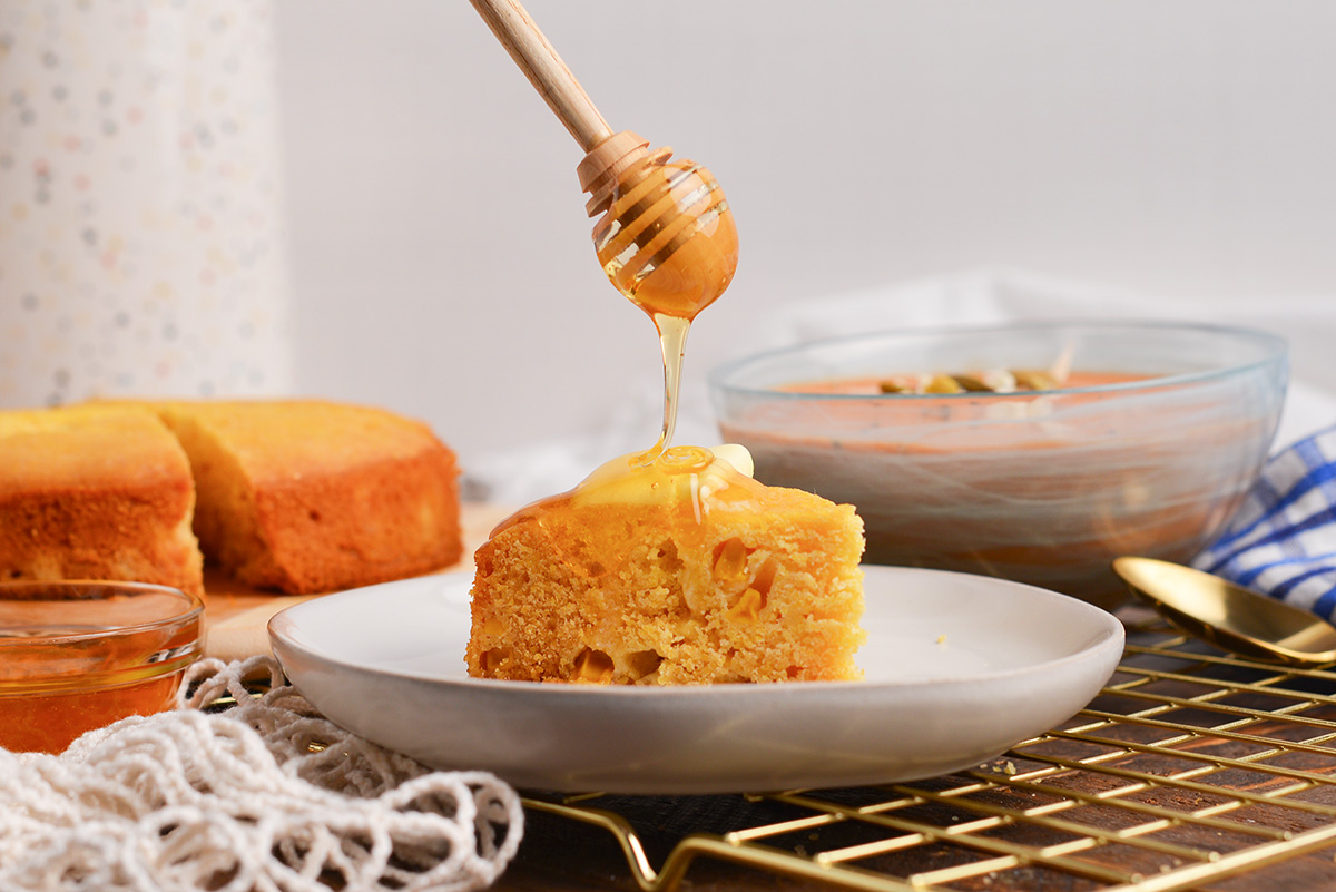 straight on shot of honey dripping onto cornbread