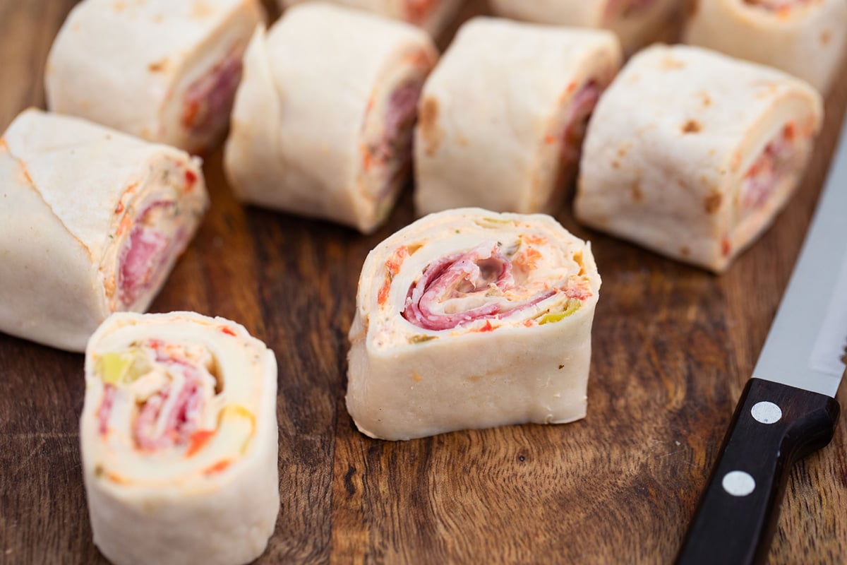 close up angled shot of sliced italian pinwheels on cutting board