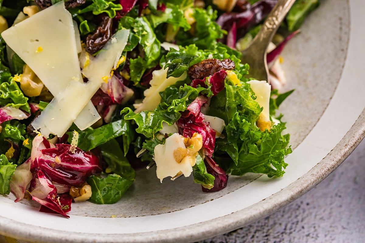 close up angled shot of bite of kale salad on fork