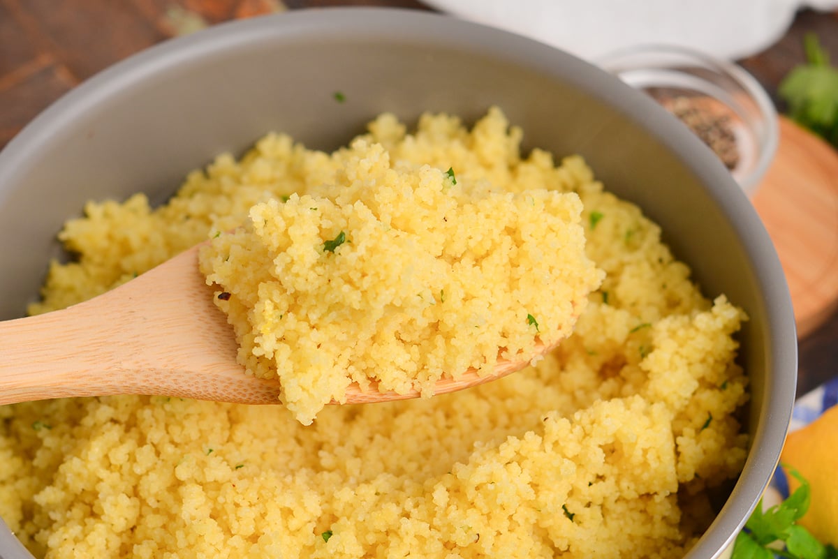 angled shot of couscous on wooden spoon
