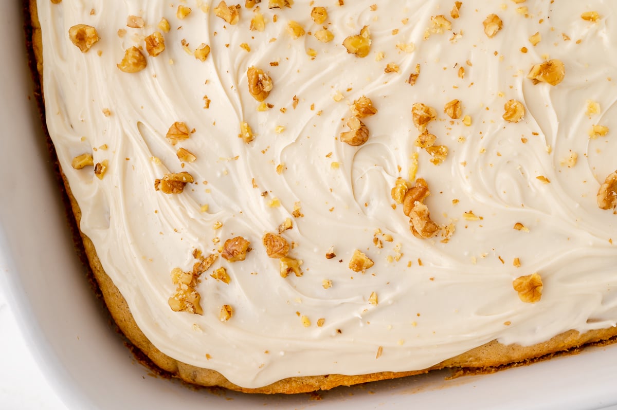 overhead cake iced with maple cream cheese frosting and topped with walnuts
