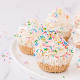 angled shot of tray of mini funfetti cheesecakes