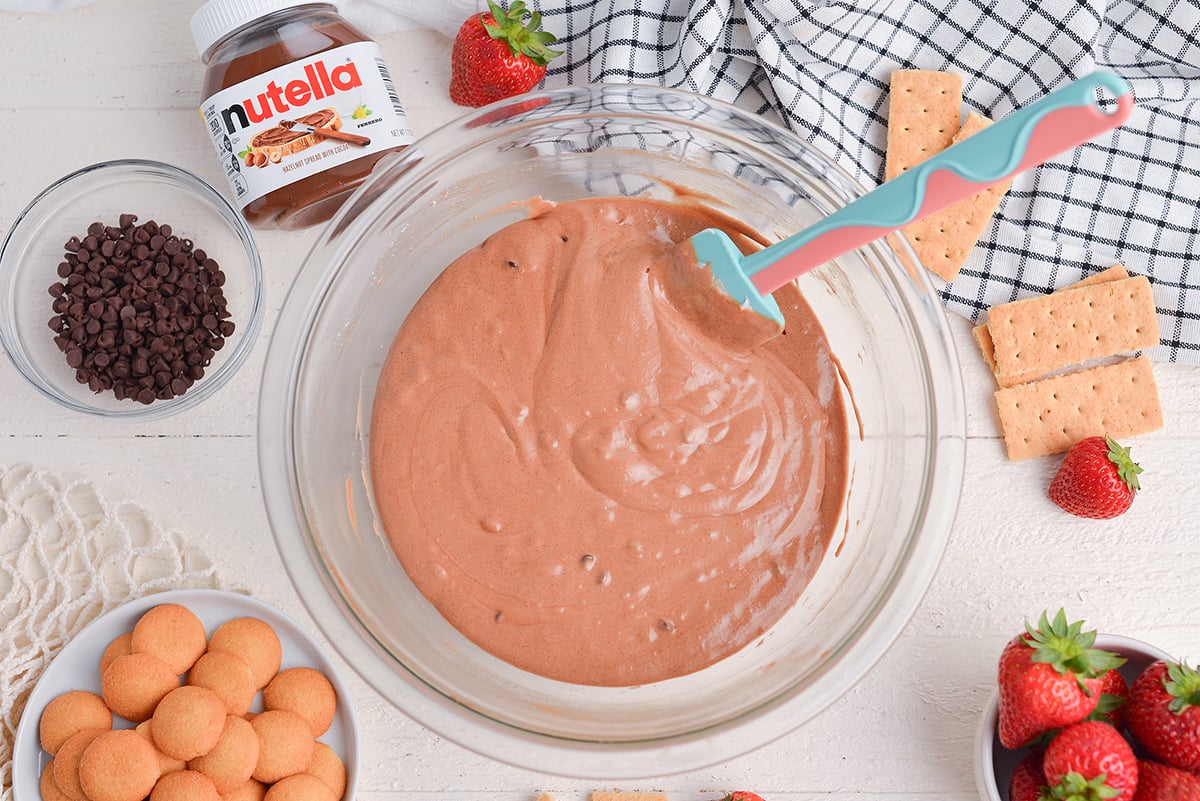 overhead shot of rubber spatula in bowl of nutella dip
