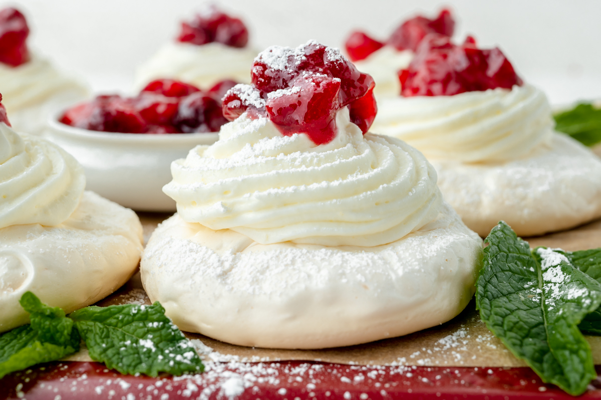straight on shot of pavlova topped with whipped cream and berries