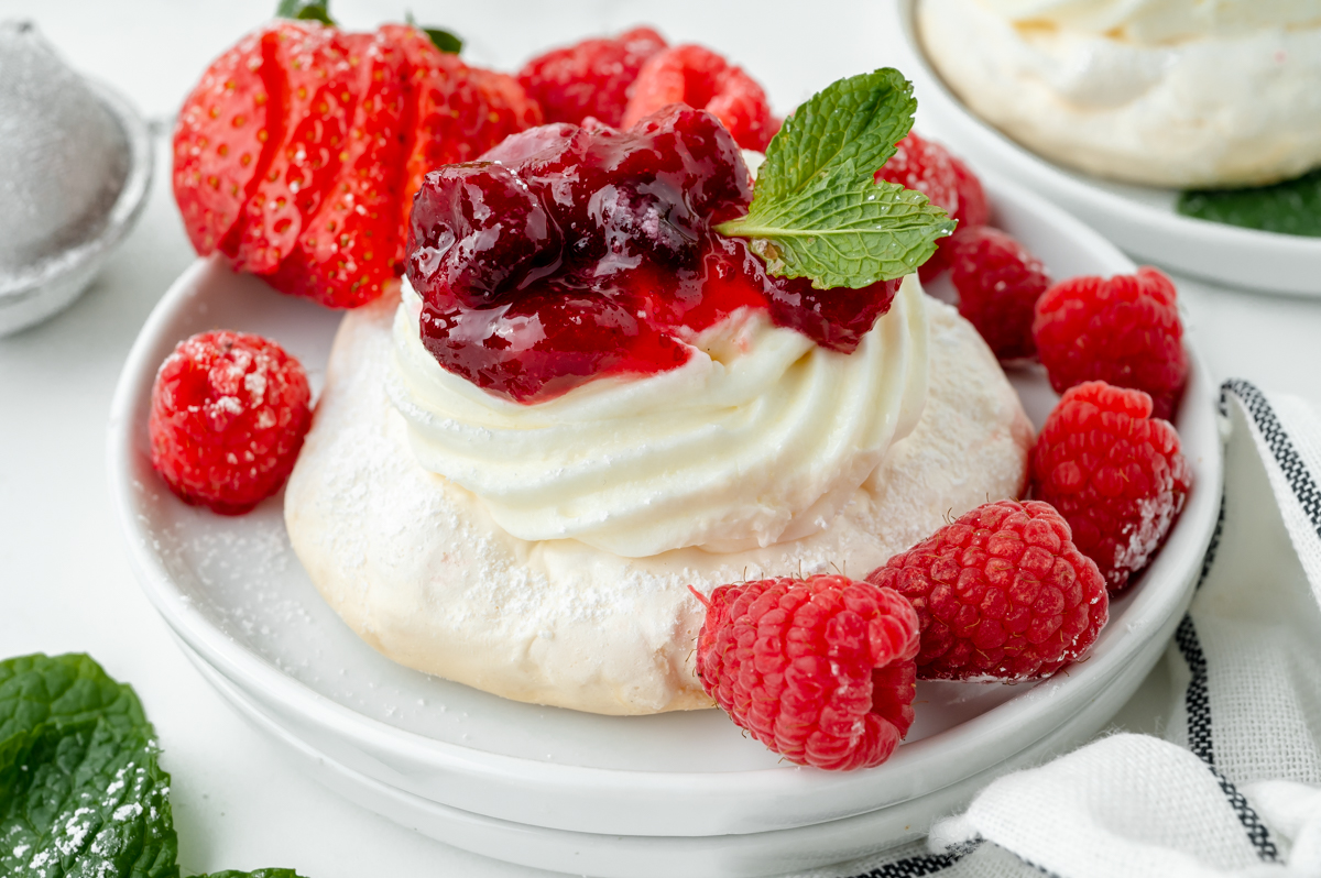 close up angled shot of pavlova on plate with berries