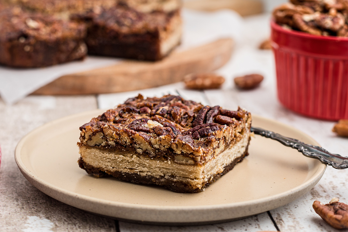 layers of pecan pie bar on a beige plate