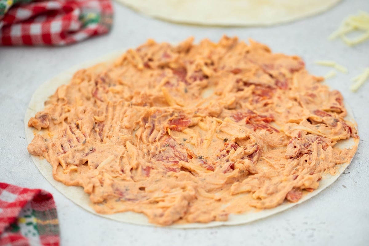 cream cheese spread onto tortilla