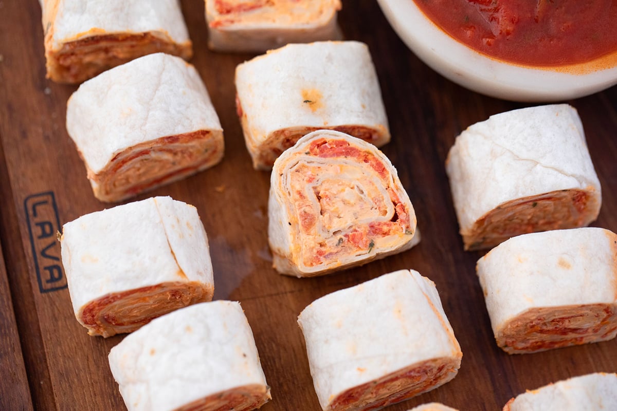 overhead shot of pizza pinwheels on wooden tray