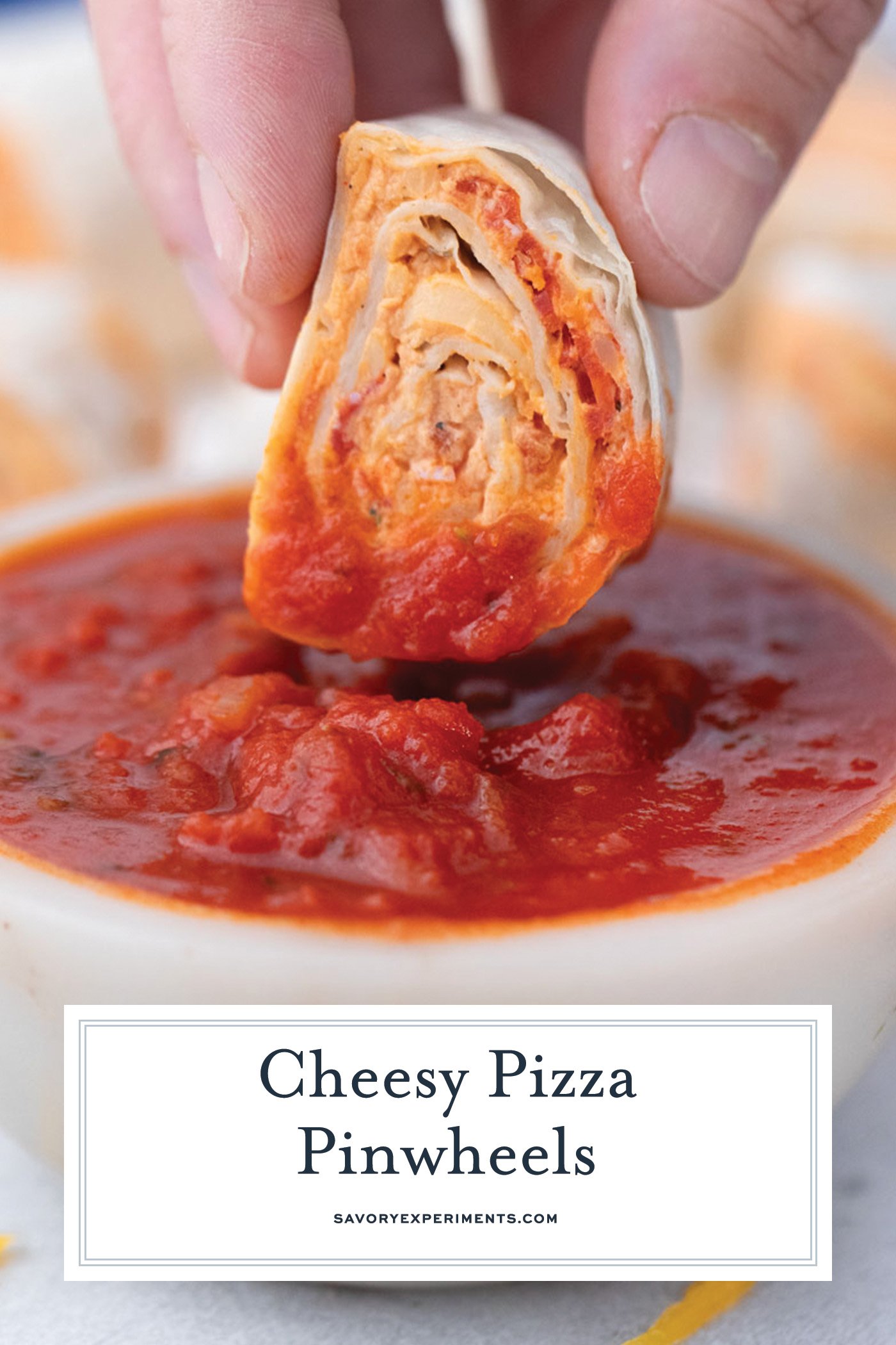 hand dipping pizza pinwheel into marinara sauce with text overlay for pinterest