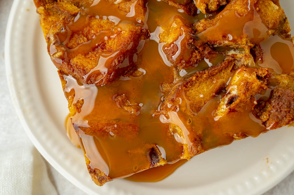 close up overhead shot of caramel sauce on slice of pumpkin bread pudding