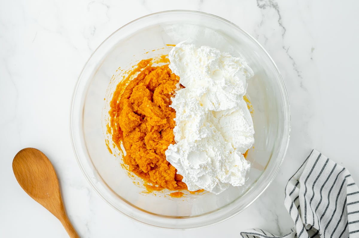 whipped topping added to pumpkin mixture in a bowl