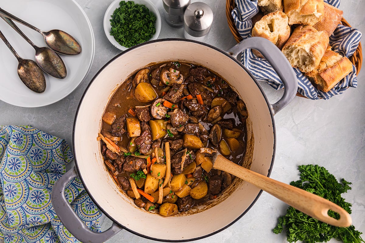 overhead shot of wooden spoon in pot of red wine beef stew