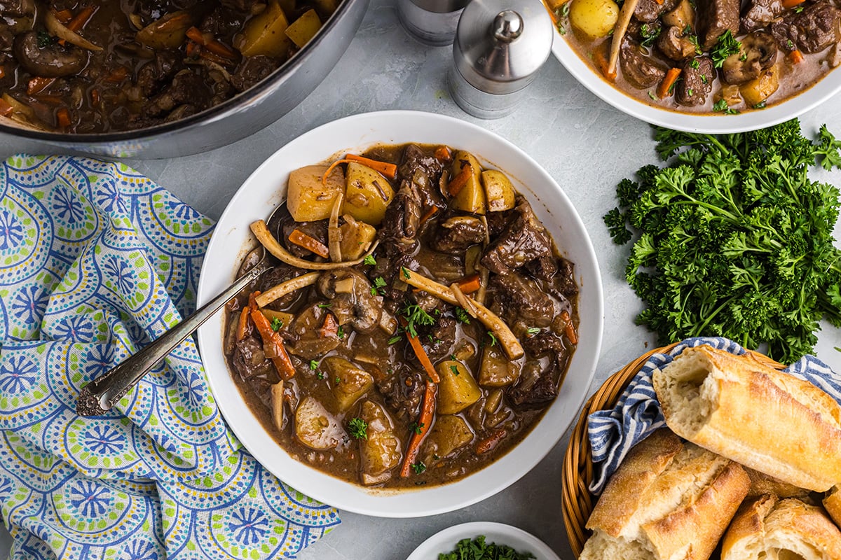 overhead shot of spoon in bowl of red wine beef stew